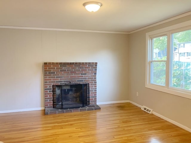 unfurnished living room with ornamental molding, a fireplace, and light hardwood / wood-style flooring