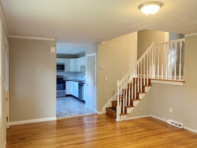 interior space with hardwood / wood-style flooring, sink, and a textured ceiling