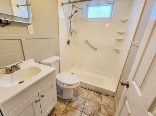 bathroom featuring vanity, toilet, and a shower