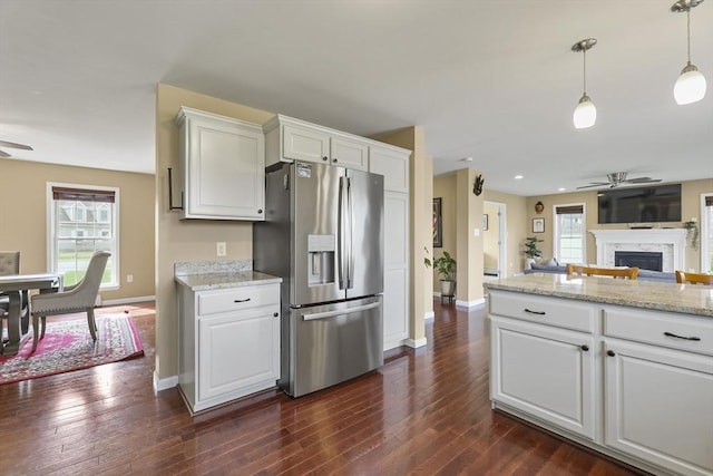 kitchen featuring stainless steel refrigerator with ice dispenser, ceiling fan, baseboards, and white cabinets