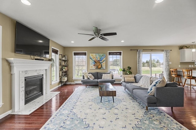 living room with dark wood-style flooring, a ceiling fan, recessed lighting, a baseboard radiator, and baseboards