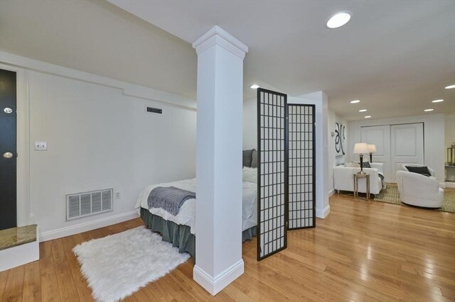 hallway with light wood-style floors, baseboards, recessed lighting, and visible vents