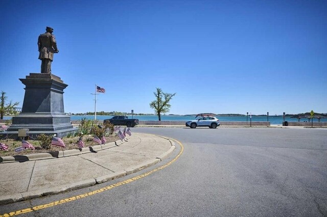 view of road with a water view, sidewalks, and curbs