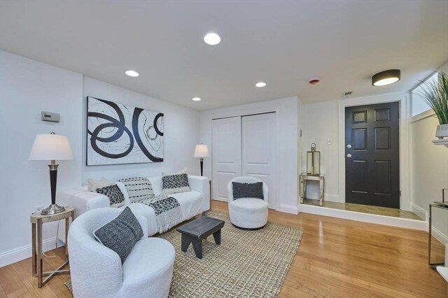 living area featuring recessed lighting, baseboards, and light wood finished floors