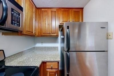 kitchen with light stone counters and stainless steel appliances