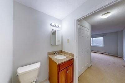 bathroom with vanity, toilet, and baseboard heating