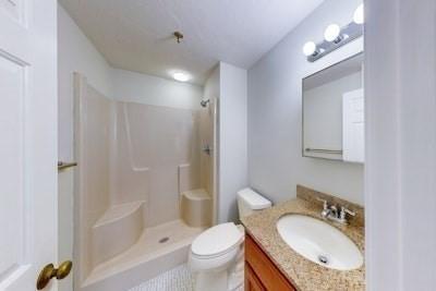 bathroom with a shower, vanity, and toilet