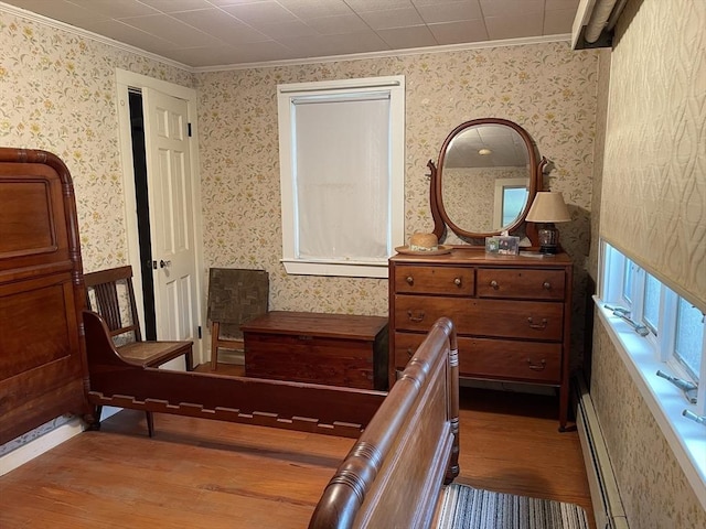 57 Harrington St, Falmouth, MA 02536 - bedroom featuring wallpapered walls, ornamental molding, a baseboard heating unit, and wood finished floors