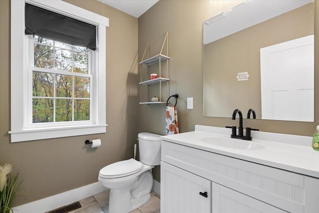 bathroom featuring toilet, vanity, baseboards, and visible vents