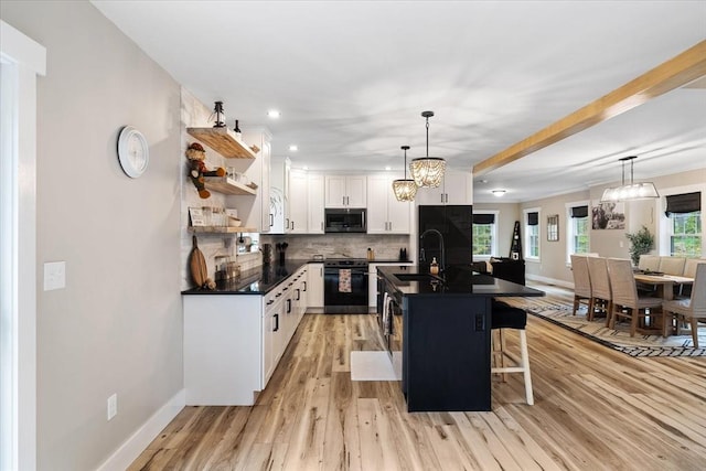 kitchen featuring electric range, stainless steel microwave, dark countertops, and open shelves