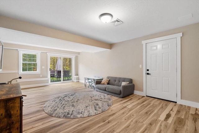 living room featuring visible vents, baseboards, and wood finished floors