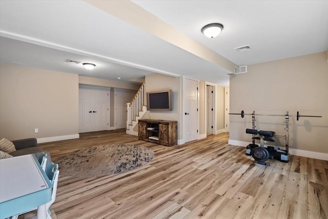 interior space featuring stairs, visible vents, baseboards, and wood finished floors