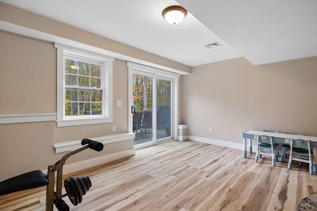 exercise room with light wood-type flooring