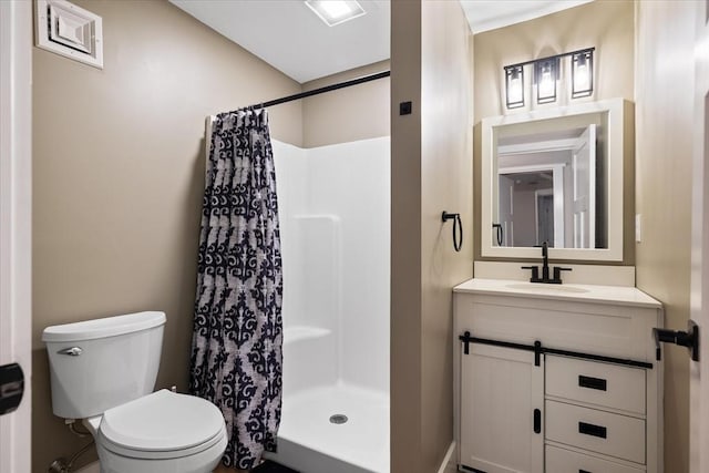 bathroom with toilet, a shower stall, and vanity