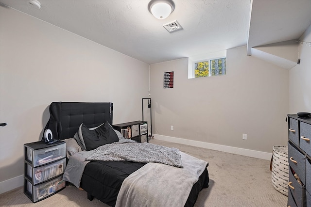 bedroom with light carpet and a textured ceiling