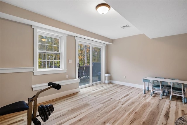 workout room featuring visible vents, baseboards, and wood finished floors