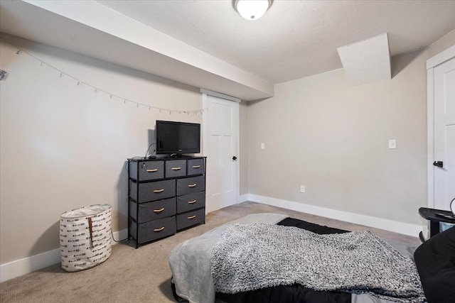 bedroom with baseboards and light colored carpet