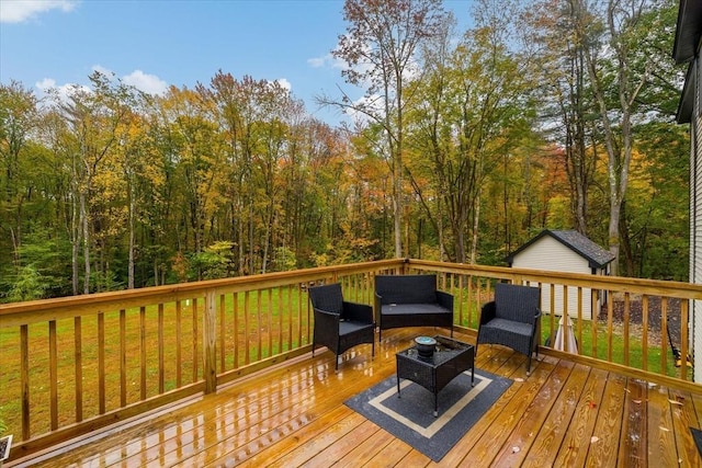 wooden terrace with outdoor lounge area and a view of trees