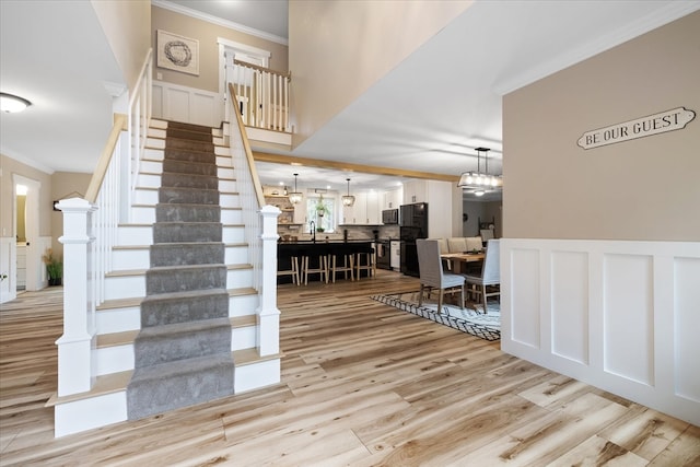 staircase with ornamental molding and hardwood / wood-style flooring