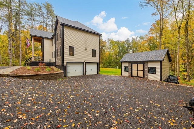 view of side of property with an outbuilding, driveway, and an attached garage
