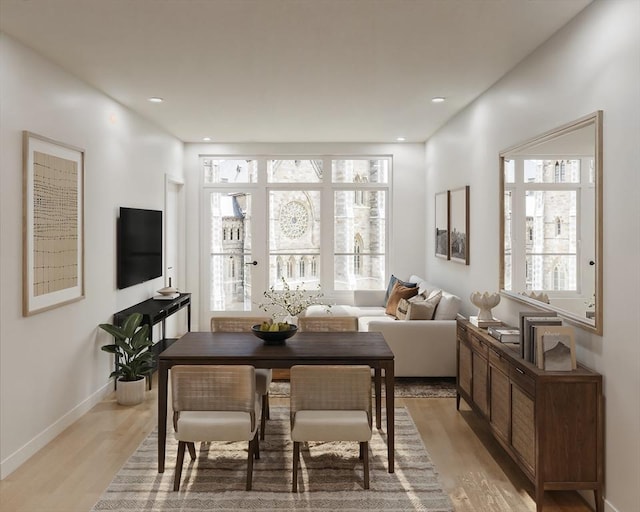 living room featuring light wood-style flooring, plenty of natural light, and baseboards