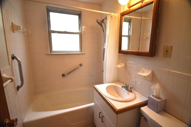full bath with shower / bath combination with curtain, vanity, tile walls, and toilet