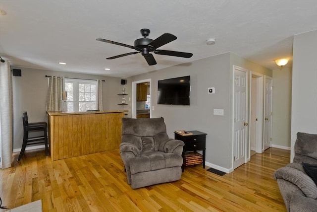 living room with wood-type flooring and ceiling fan