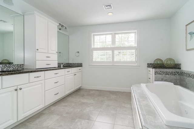 bathroom featuring vanity, tile patterned floors, and tiled tub