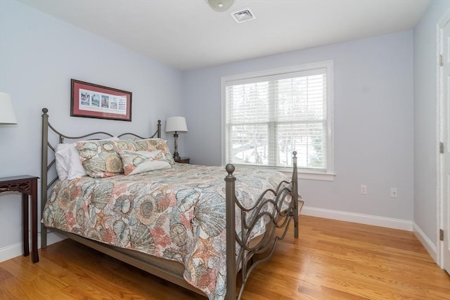 bedroom with light hardwood / wood-style floors and multiple windows