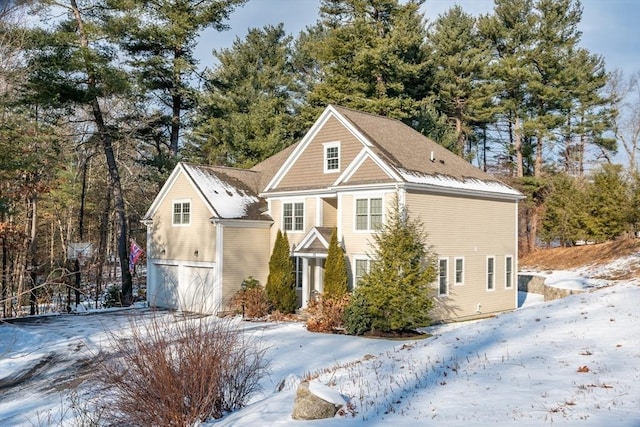 snow covered property featuring a garage