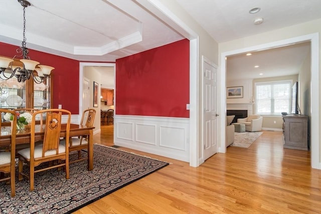 dining area featuring a notable chandelier, a tray ceiling, and wood-type flooring