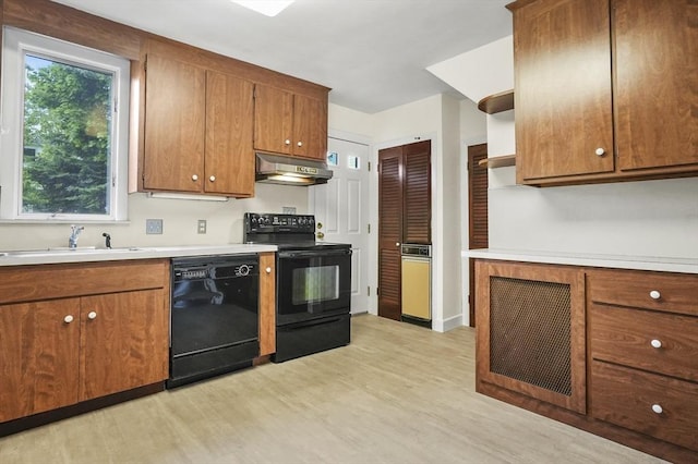 14 Lyman Ter, Waltham, MA 02452 - kitchen with black appliances, light wood-style floors, exhaust hood, a sink, and brown cabinets