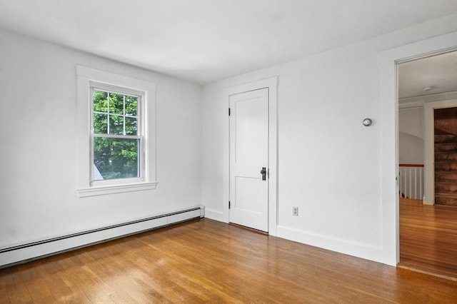 14 Lyman Ter, Waltham, MA 02452 - unfurnished bedroom featuring a baseboard radiator and wood finished floors