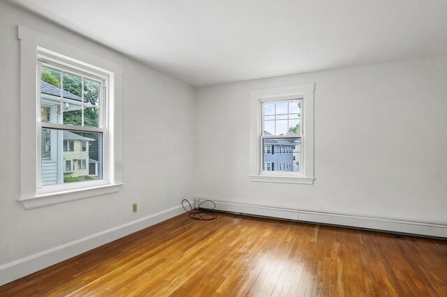14 Lyman Ter, Waltham, MA 02452 - empty room with wood-type flooring, baseboards, and a baseboard radiator