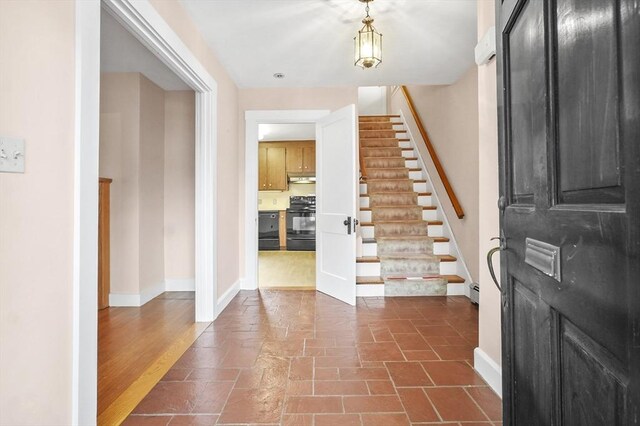 14 Lyman Ter, Waltham, MA 02452 - foyer entrance with stairway, baseboards, and a baseboard radiator