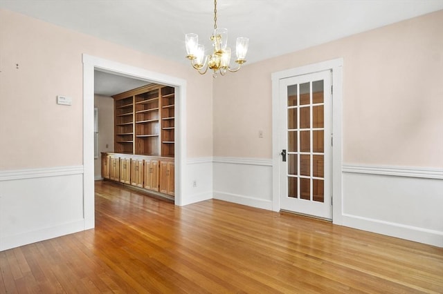 14 Lyman Ter, Waltham, MA 02452 - unfurnished dining area with a chandelier, wood finished floors, built in shelves, and baseboards
