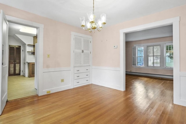 14 Lyman Ter, Waltham, MA 02452 - unfurnished dining area featuring baseboard heating, a chandelier, wood finished floors, and a wainscoted wall
