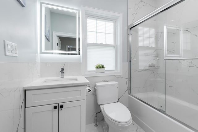 6 Fallon Cir, Braintree, MA 02184 - bathroom featuring tile walls, marble look tiles, vanity, toilet, and shower / bath combination with glass door