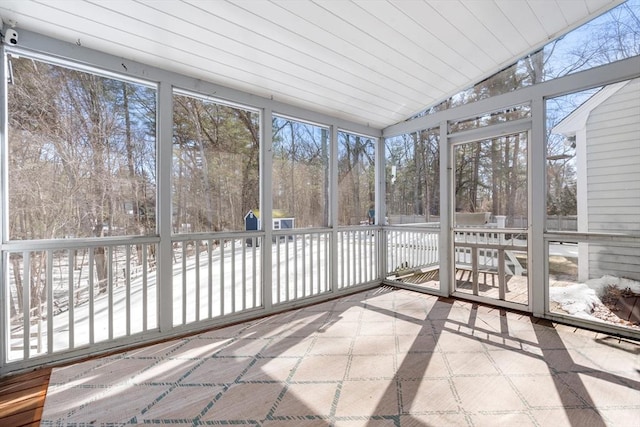 unfurnished sunroom featuring a healthy amount of sunlight, wood ceiling, and vaulted ceiling