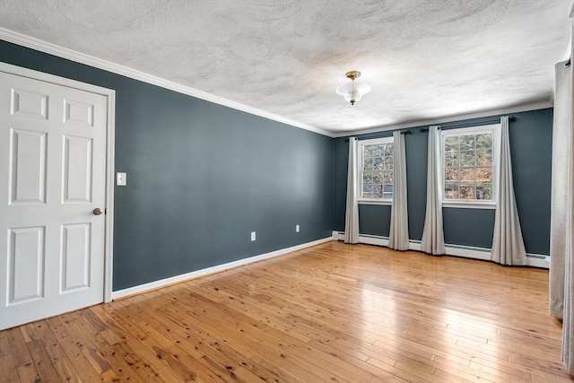 unfurnished room with ornamental molding, baseboards, and hardwood / wood-style flooring