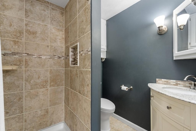 full bathroom featuring toilet, a shower stall, vanity, baseboards, and tile patterned floors