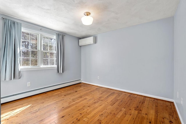 unfurnished room with an AC wall unit, a baseboard radiator, wood-type flooring, and baseboards