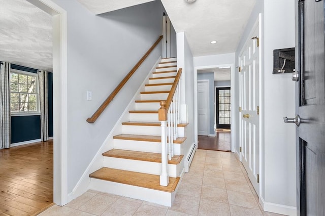 staircase featuring tile patterned flooring, baseboards, and baseboard heating