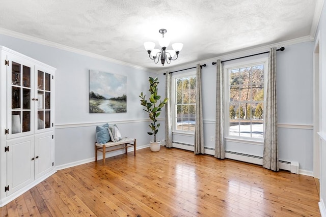 unfurnished room with crown molding, a notable chandelier, and light wood-style flooring