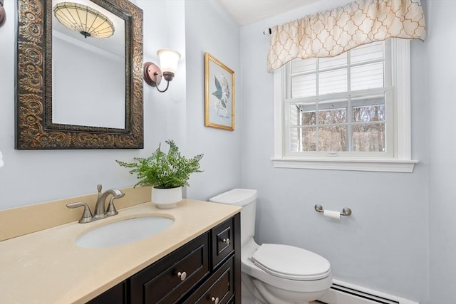 bathroom with toilet, a baseboard heating unit, and vanity