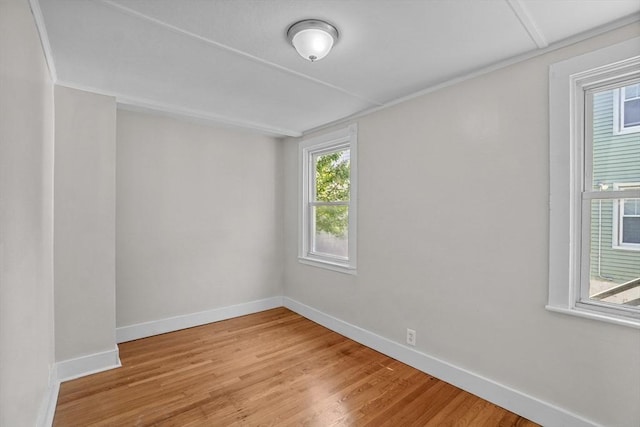 spare room featuring light wood finished floors and baseboards