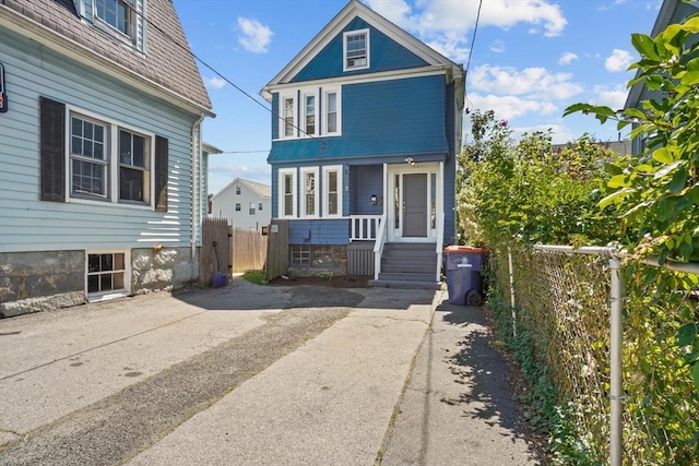 view of front of home with fence and mansard roof