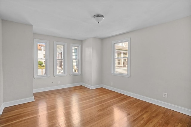 empty room featuring light wood-type flooring and baseboards