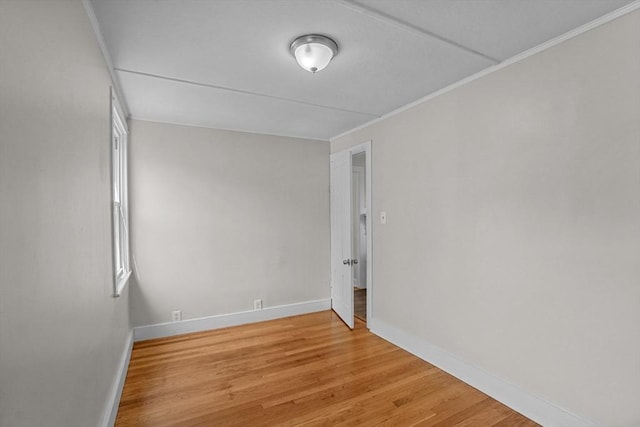 unfurnished room featuring light wood-style floors, baseboards, and crown molding