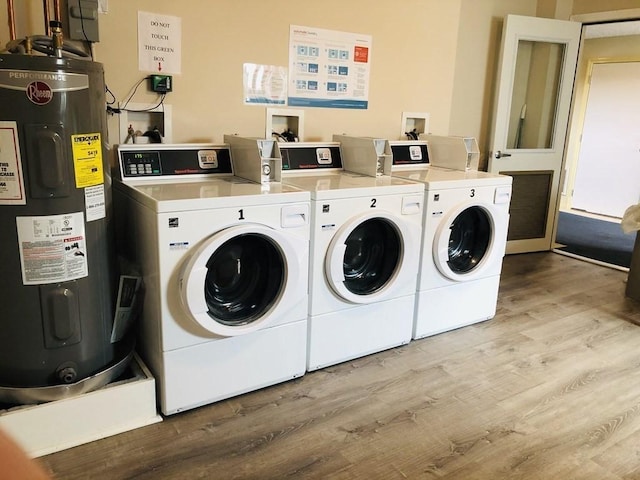 laundry room featuring light wood-type flooring, electric water heater, and washing machine and clothes dryer